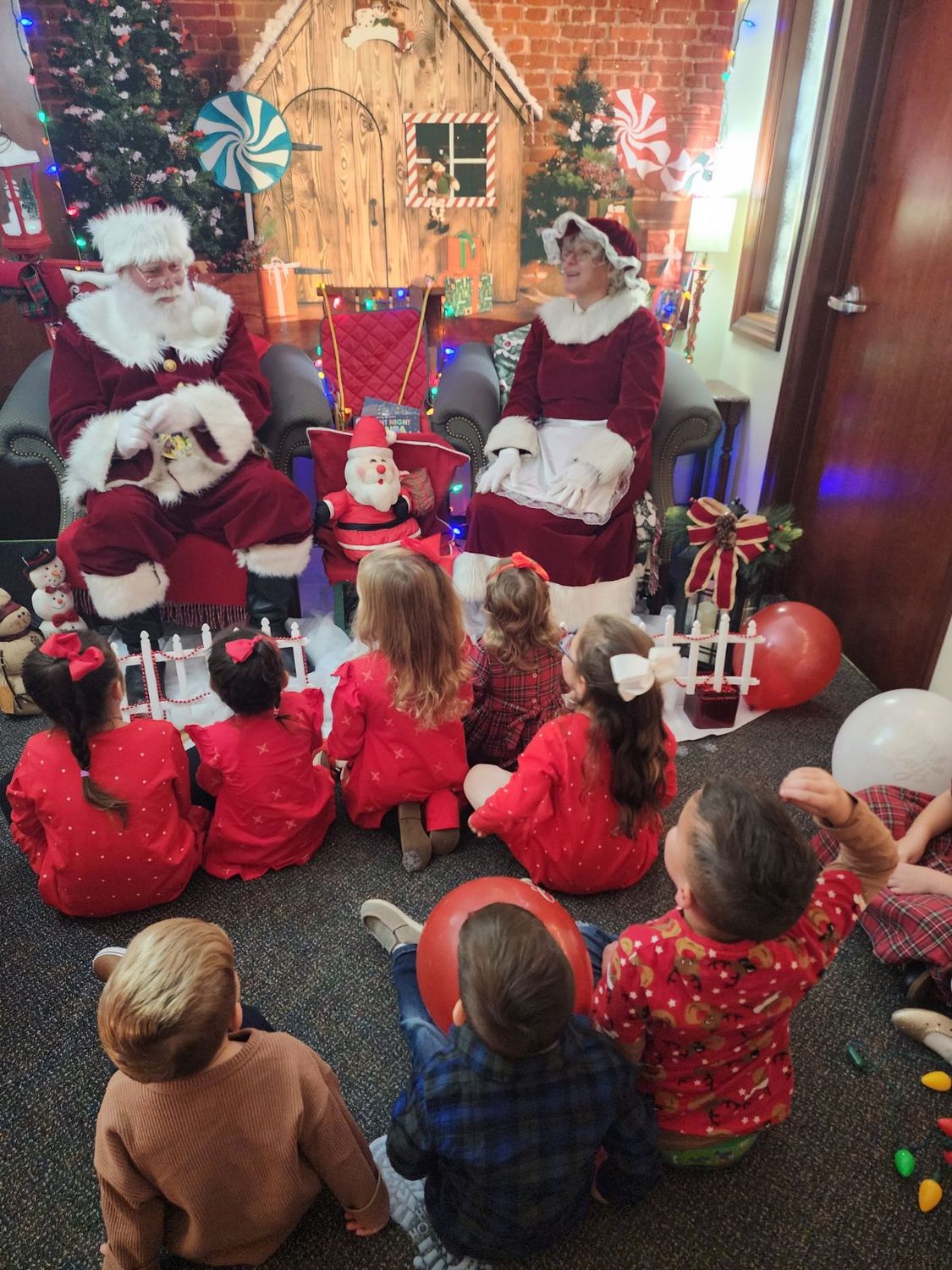 Santa and Mrs. Claus at story time with a group of little ones